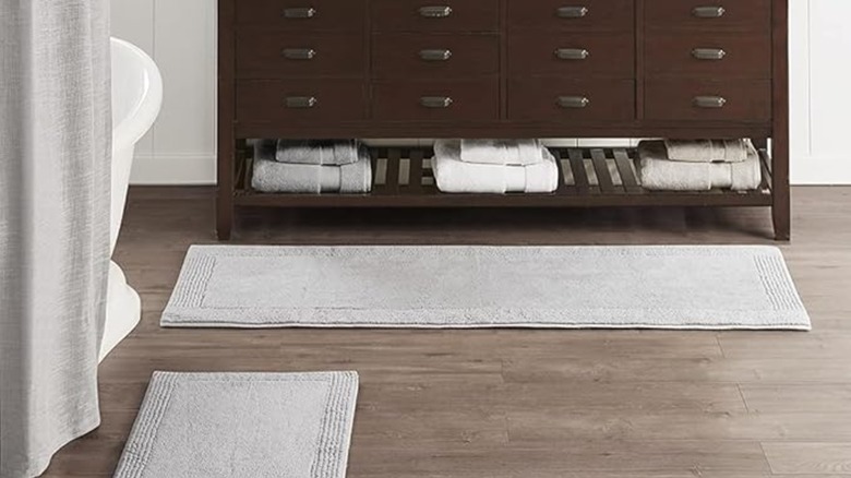 A bathroom with two large bath mats