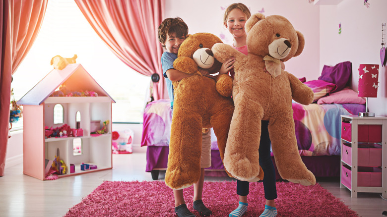 Two kids holding giant stuffed teddy bears