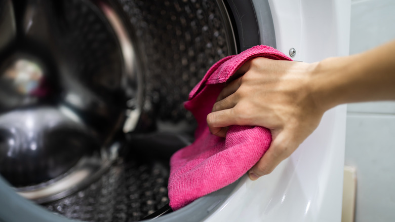 Wiping inside of washing machine with pink cloth