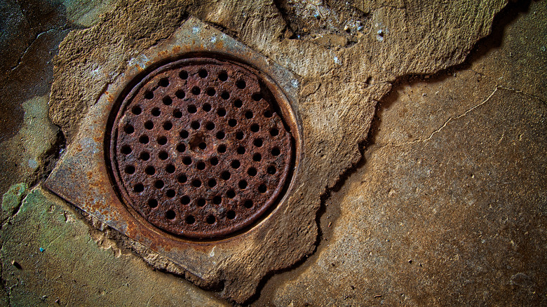 Rusted basement drain on stone floor