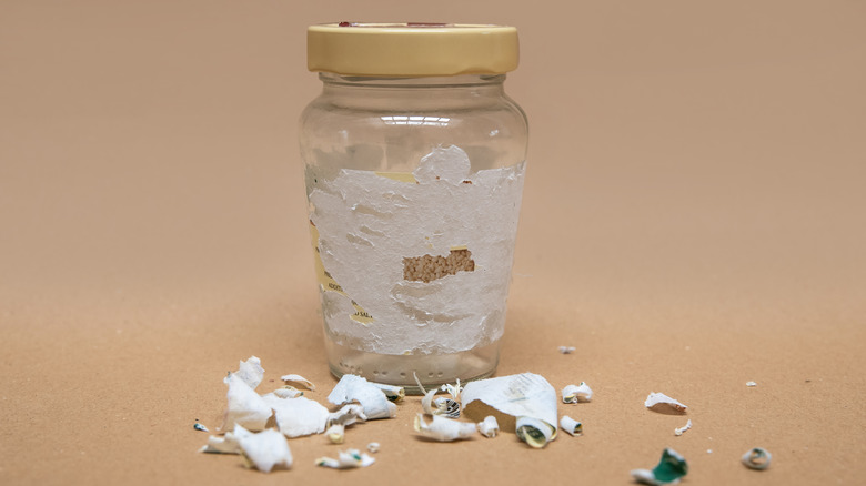 jar with partially removed sticker surrounded by sticker paper
