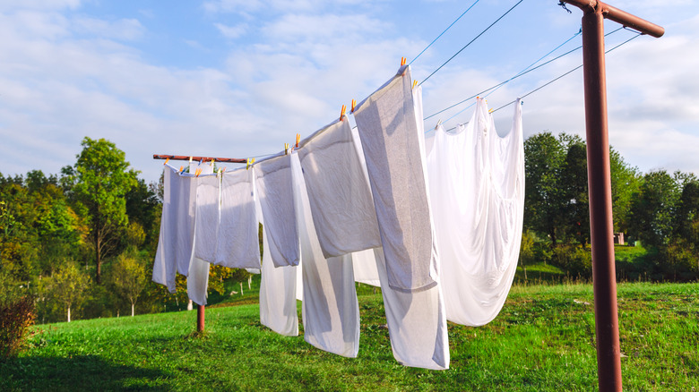 clean white sheets hanging from clothing line outside