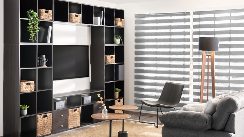 A living room with zebra blinds over the window
