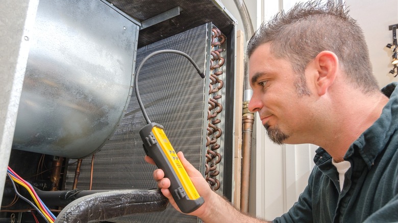 man using freon leak detector on A/C evaporator coil