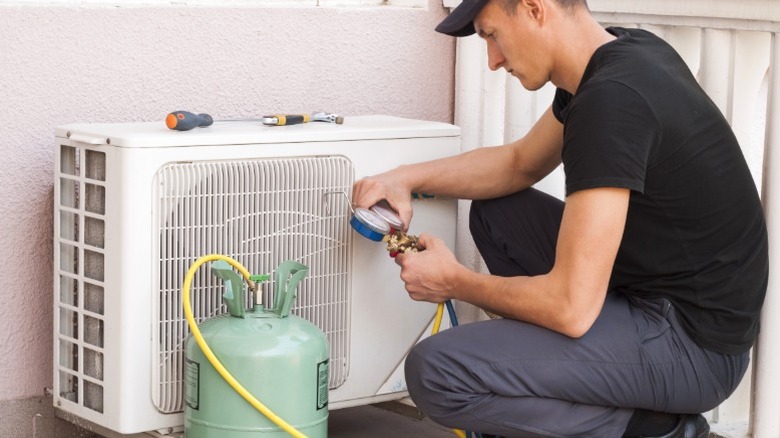 An HVAC professional safely removing freon into tank