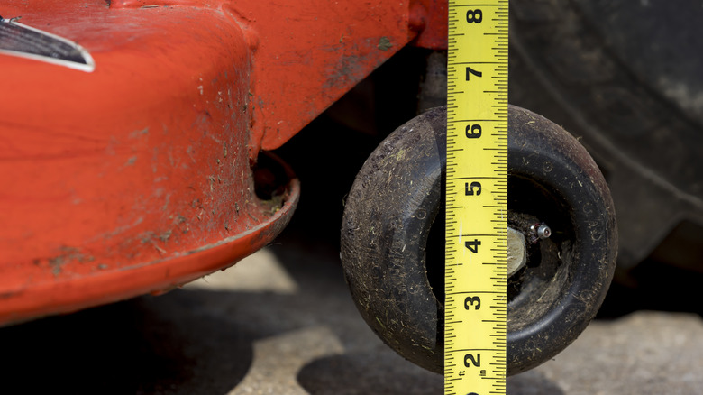 Closeup of a lawn mower and a measuring tape