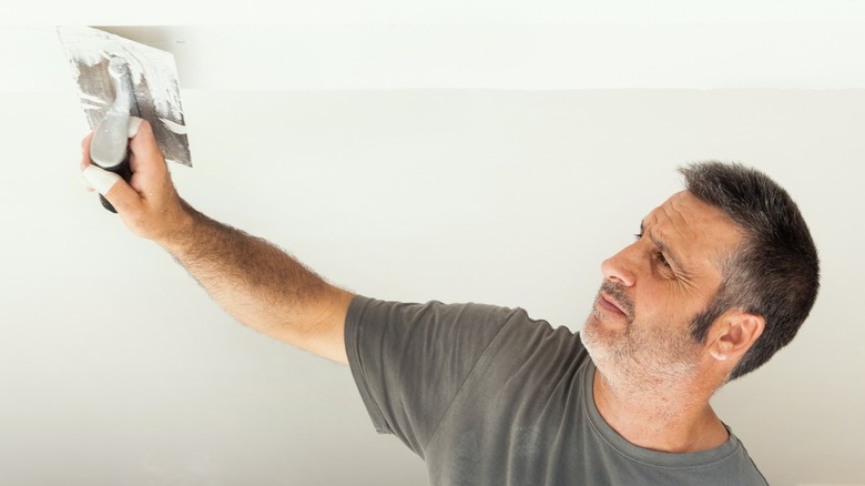 Craftsman skim coating a ceiling
