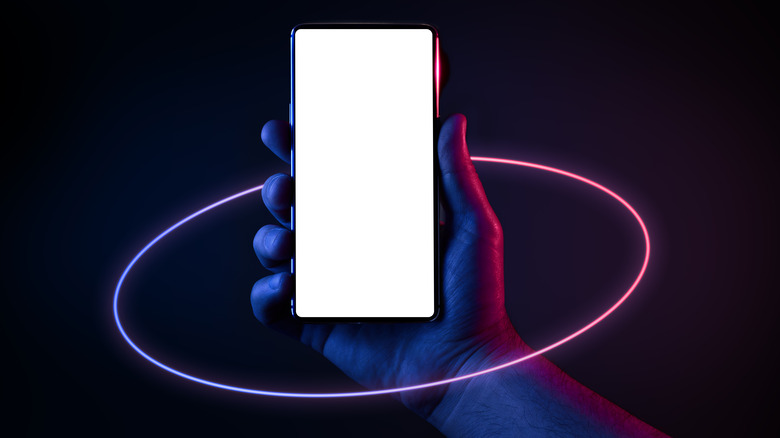 Hand holding cell phone with blank screen