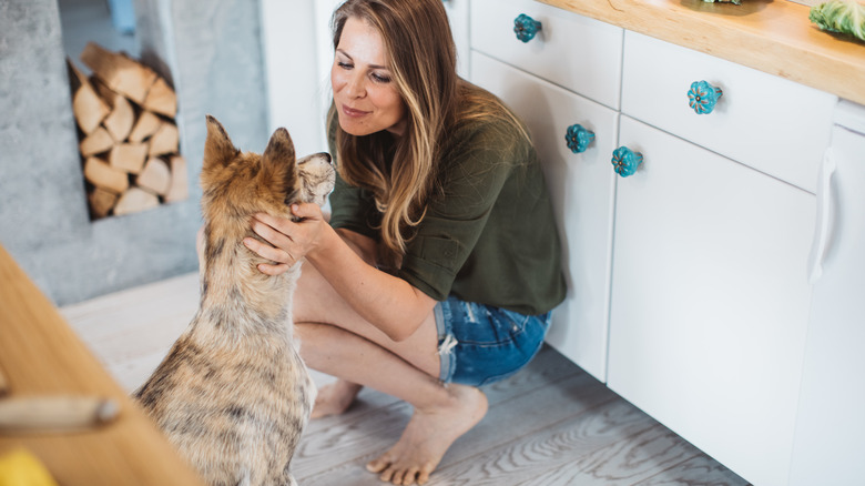 Woman with dog in kitchen