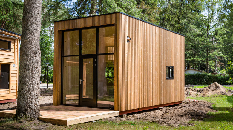 Tiny home with wood siding and large windows