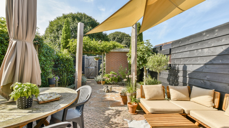 A patio with an umbrella and sails for shade