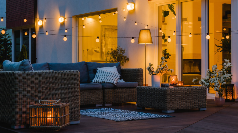 A stylish backyard patio with layered lighting at night
