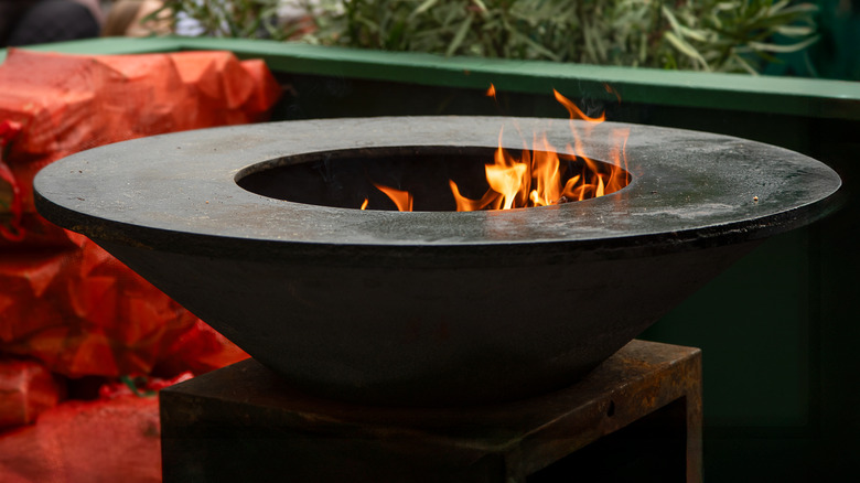 A firebowl with flames on a patio