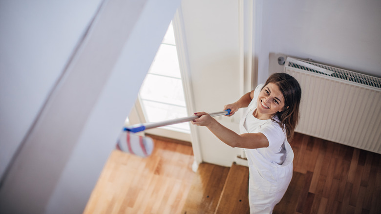 woman painting ceiling