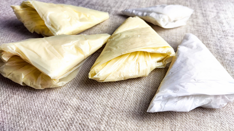 White and yellow plastic grocery bags folded into triangles for storage.