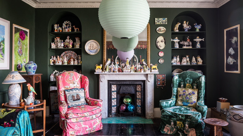 Maximalist living room with trinkets displayed on shelves and above the fireplace