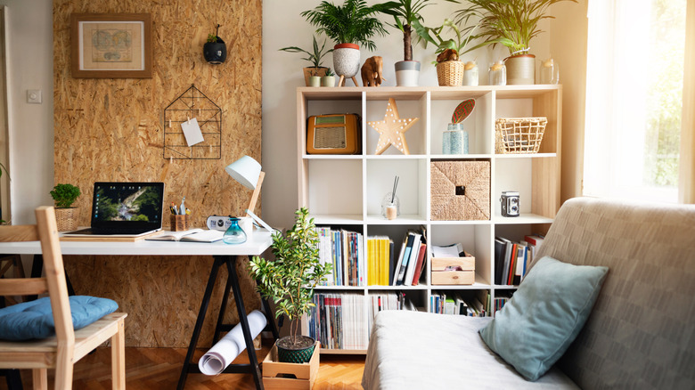 Living room with open shelving and laptop on table