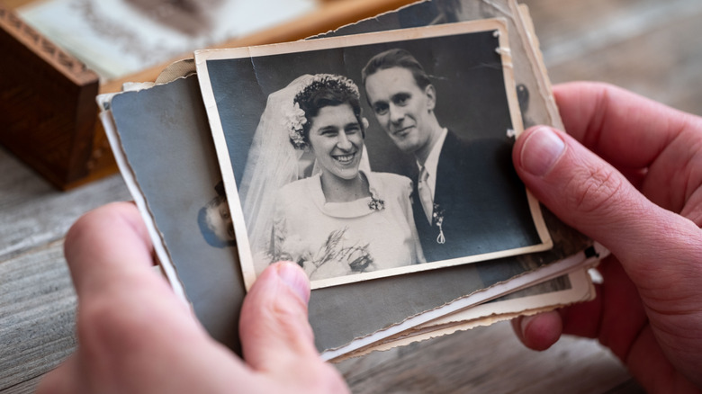 Hands holding old wedding photographs