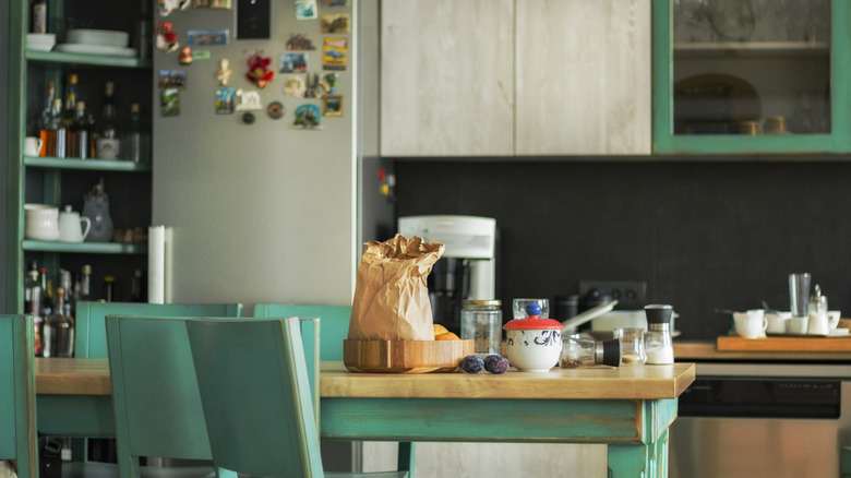 Kitchen with visual clutter on shelves, countertops and refrigerator doors.