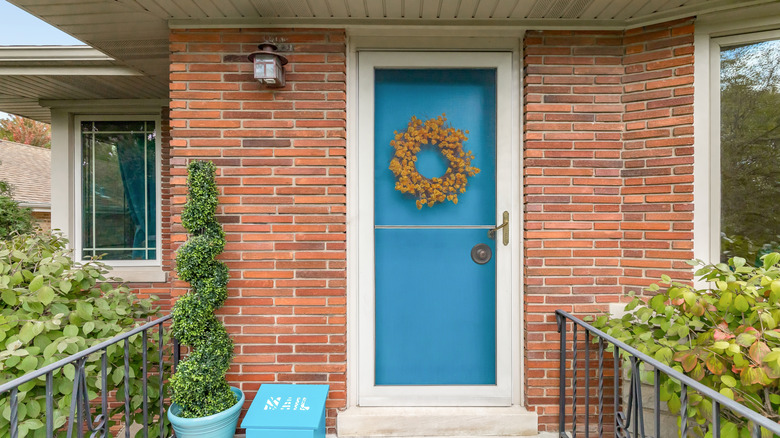 modest home with blue front door with wreath
