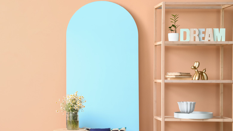 bookshelf with mirror next to it