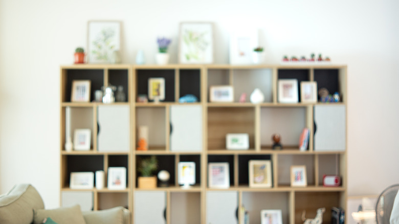 bookshelf with photos and art on top
