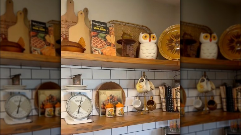 A kitchen with vintage, autumnal decor on shelves