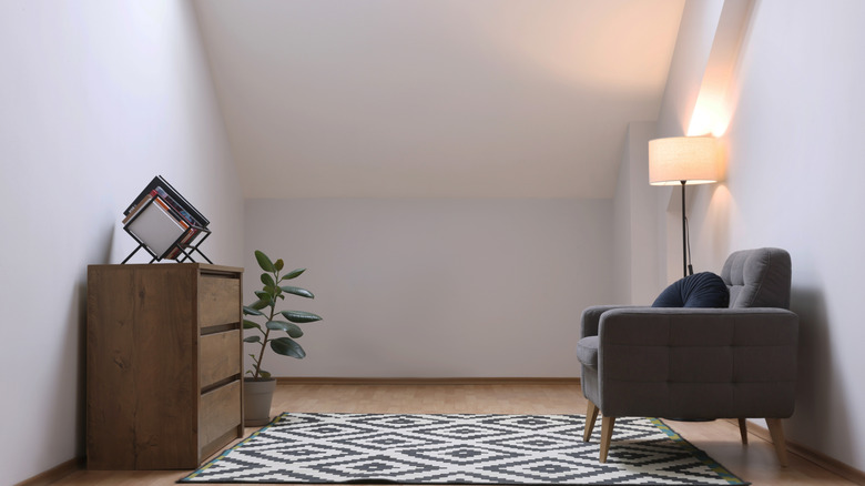 Room with undecorated slanted ceilings