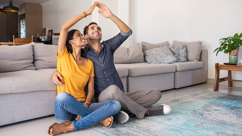 couple sitting on apartment floor 