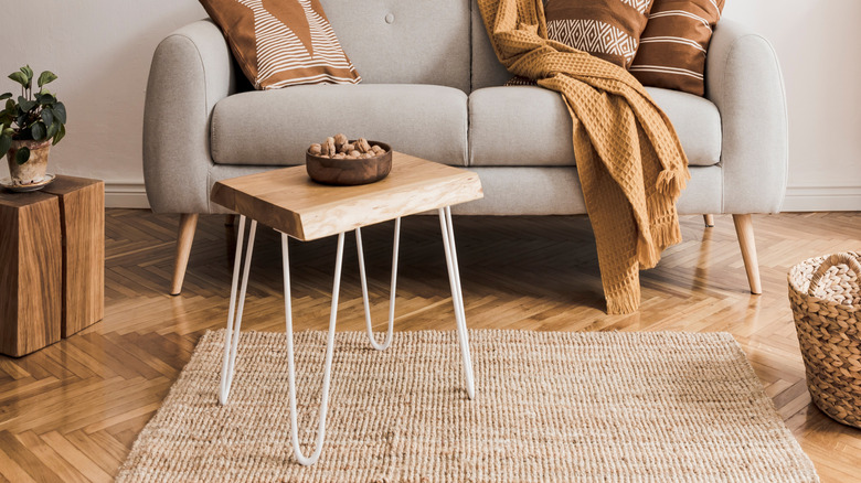 couch with orange blanket and pillows
