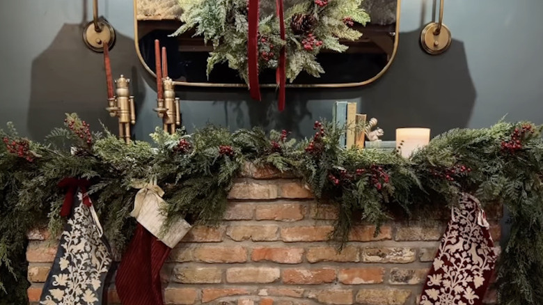 A mantle decorated by Joanna Gaines with garlands and accent pieces at a Magnolia store.