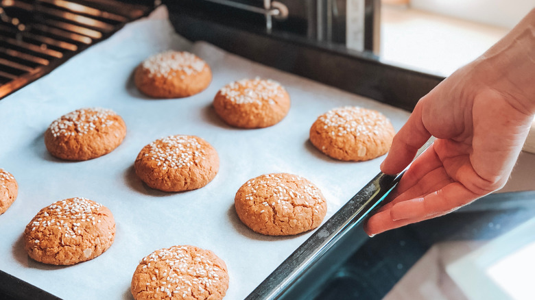 woman taking out baking tray