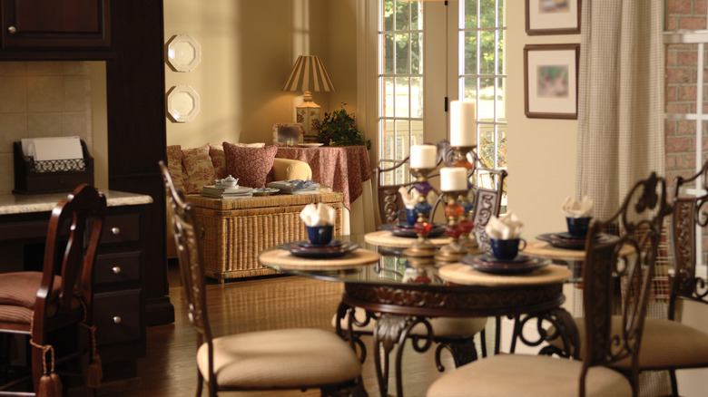 Southern style interior with fully set dining room table and furnished living room in the backgroun