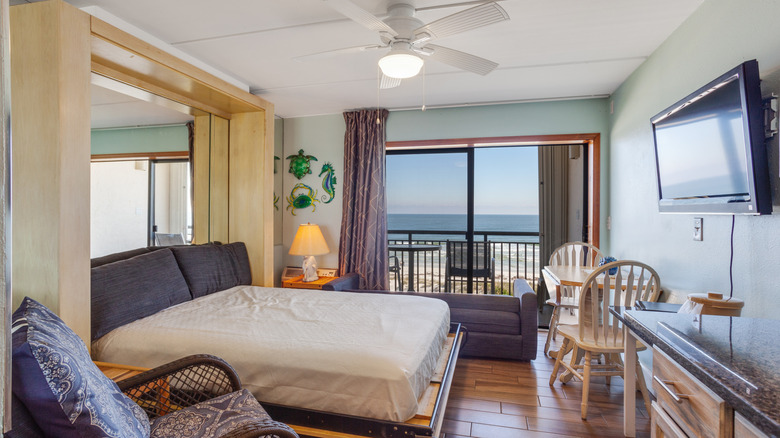 Opened Murphy bed in studio apartment with ocean view