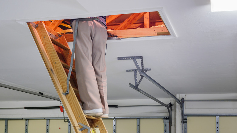 man climbing into an attic