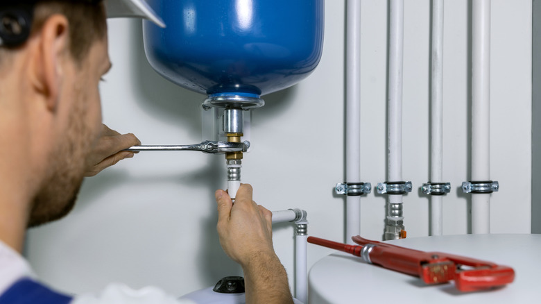 Plumber installing an expansion tank