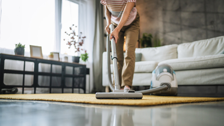 Person using vacuum on rug