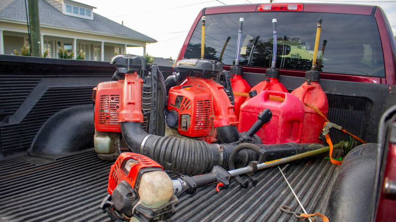 Truck with gas cans and lawn equipment in bed