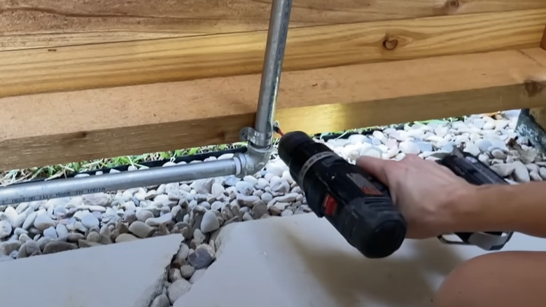 Installing pipes for a shower on a wooden wall