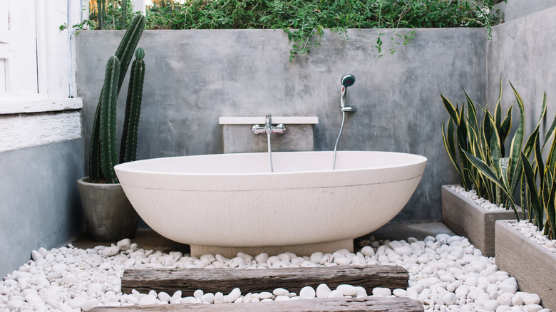 Outdoor soaking tub in a garden with plants