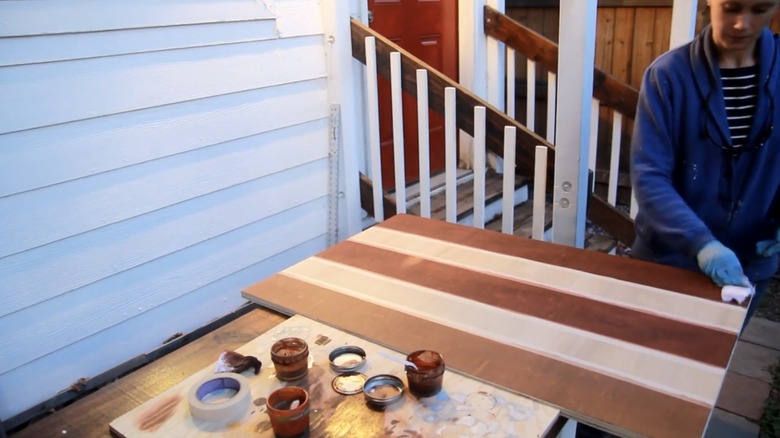 Women uses paints to stain wood
