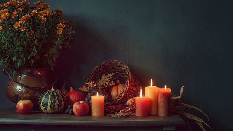 A cornucopia basket on a table with candles