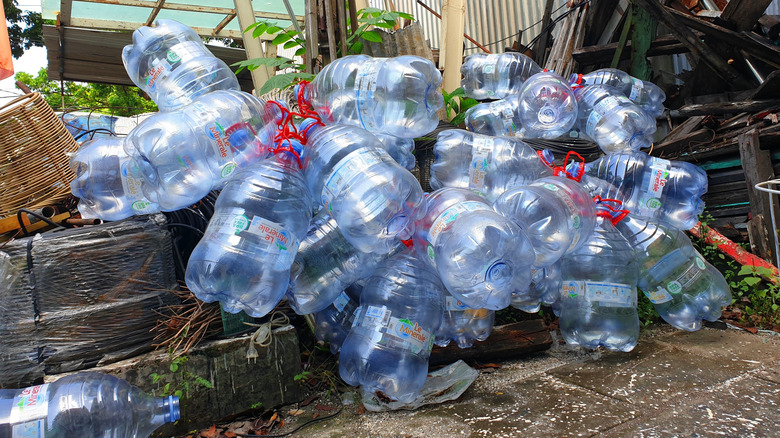 A pile of empty plastic bottles on the ground at a recycling center.