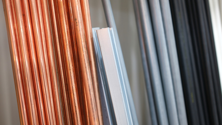 Metal pipes leaning against the wall in a hardware store