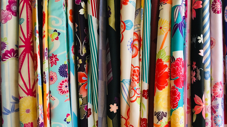 A row of colorful fabric rolls with different colors and patterns.