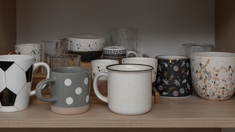 Several different types of mugs stashed away in a cabinet