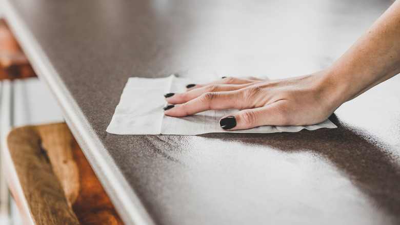 Hand wiping counter with disinfecting wipe