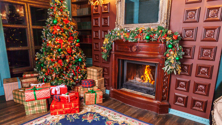 home library with fireplace and Christmas tree with red ornament decorations.