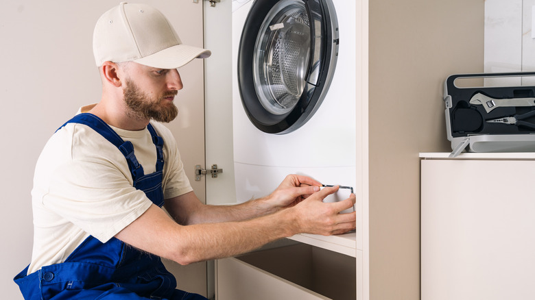 Man opening up front loader filter door