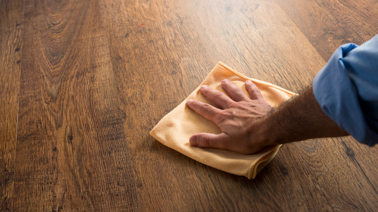 Man cleaning wood floor cloth